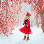 赤い服を着て雪道を歩く女の子