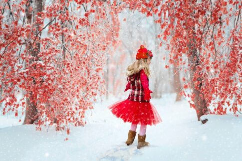 赤い服を着て雪道を歩く女の子